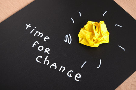 chalk marker writing on black daughter, time for change, motivational slogan, yellow crumpled paper as light bulb, idea concept, creative artの写真素材