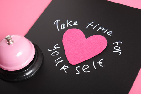 inscription take time for yourself and felt heart, text with white chalk marker on black board,...