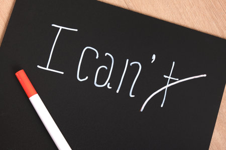 I can I can't sign on black matte plastic board, motivational slogan concept, creative text with chalk marker on boardの写真素材