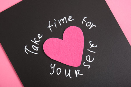 inscription take time for yourself and felt heart, text with white chalk marker on black board,...