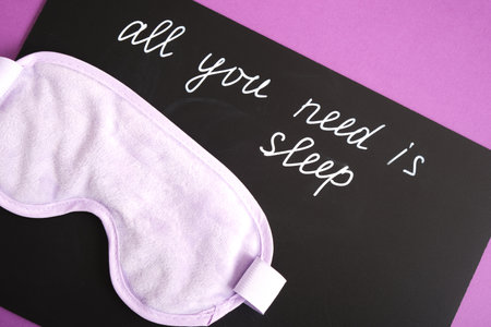 on a black chalk board the inscription all you need is sleep, a sleep mask on a purple background, insomnia and sleep disorders conceptの写真素材