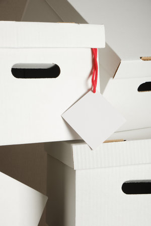 tag and pile of white cardboard boxes with slots for holding, storage boxes mock upの写真素材