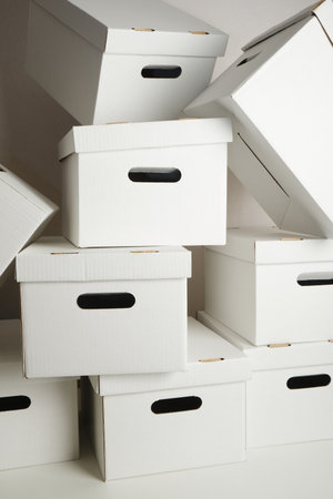 pile of white cardboard boxes with slots for holding, storage boxes