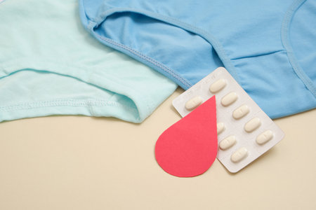 women's comfortable panties small size, blood drop from paper and medical pills, concept of women's health, contraception and PMS first menstruationの写真素材