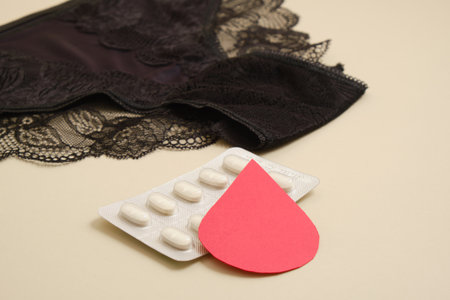 women's comfortable panties small size, blood drop from paper and medical pills, concept of women's health, contraception and PMS first menstruationの写真素材