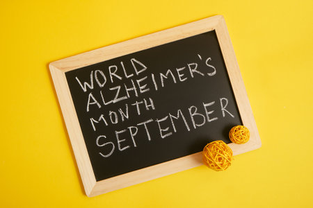 chalk lettering September alzheimer awareness month, brain decline concept yellow backgroundの写真素材