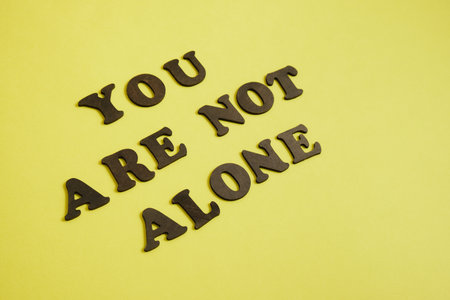 inscription made of wooden letters "you are not alone"の写真素材
