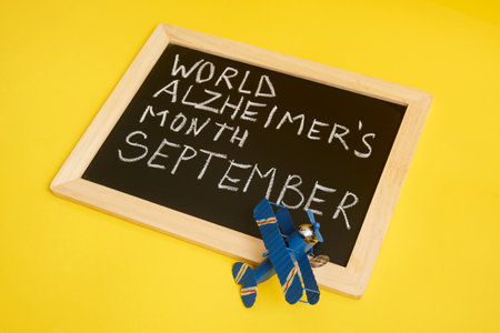chalk lettering September alzheimer awareness month, brain decline concept yellow backgroundの写真素材