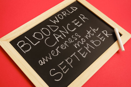 blood cancer concept, blood cancer awareness month, chalk writing on black board, red backgroundの写真素材