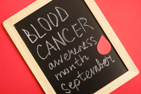 blood cancer concept, blood cancer awareness month, chalk writing on black board, red backgroundの写真素材