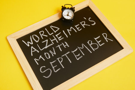 chalk lettering September alzheimer awareness month, brain decline concept yellow backgroundの写真素材