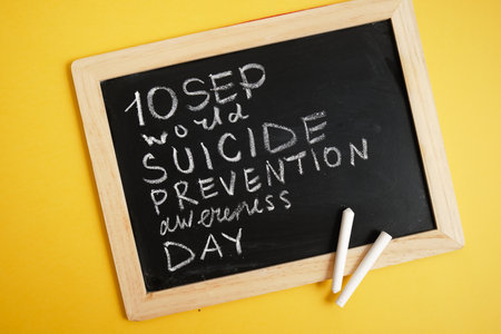 suicide inscription "September suicide prevention month" in chalk on a black chalk boardの写真素材