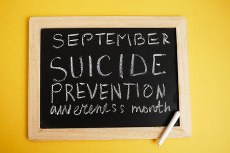 suicide inscription "September suicide prevention month" in chalk on a black chalk boardの写真素材