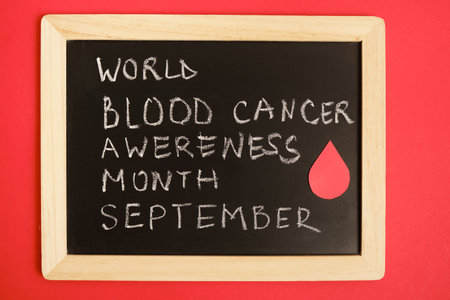 blood cancer concept, blood cancer awareness month, chalk writing on black board, red backgroundの写真素材
