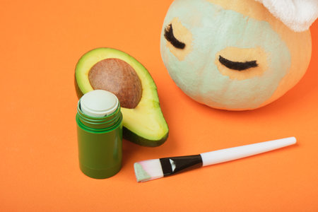Avocado mask stick concept, avocado on an orange background, autumn beauty careの写真素材