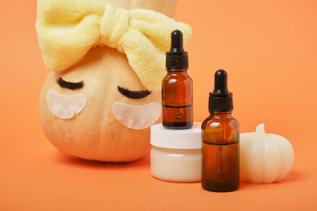 Autumn cute pumpkin with patches and cosmetic containers, autumn self-care conceptの写真素材