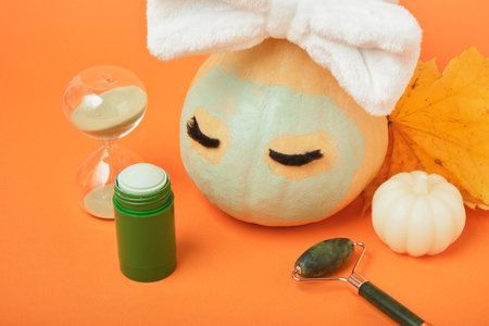 Skin care season concept, pumpkin and cosmetics on orange background, mock upの写真素材