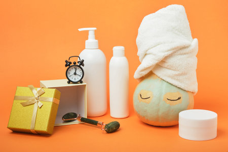 Pumpkin, gift boxes and various cosmetics on an orange background, holiday gift-giving and sales concept, autumn self-careの写真素材
