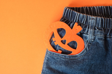 Blue jeans and a pumpkin on an orange backgroundの写真素材