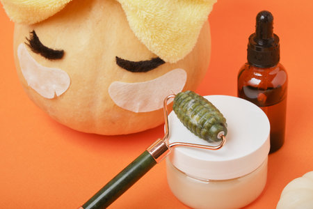 Autumn cute pumpkin with patches and cosmetic containers, autumn self-care concept, time for spaの写真素材