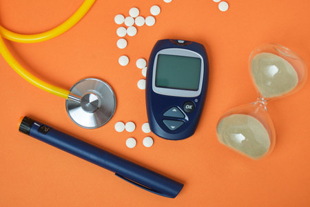 pills, stethoscope and digital blood glucose meter on orange background, hourglass as a symbol of time, autumn styleの写真素材