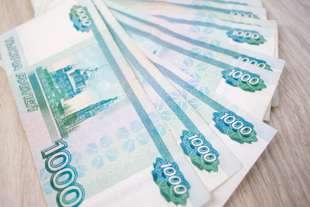 business, finance, saving, banking and people concept - close up bundle of money Russian Banknotes thousand rubles on wooden tableの写真素材