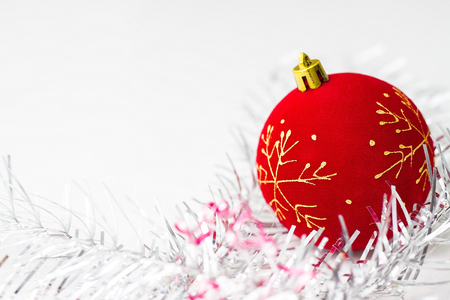 holidays, winter and celebration concept - Christmas and new year card with red ball with a golden snowflake and silver decorations on white background. copyspaceの写真素材
