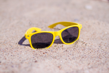 yellow Sunglasses on sandy beach in summer - holidays, relax, travel and vacantion conceptの写真素材