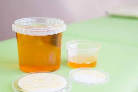 depilation and beauty concept - big and small jar sugar paste or wax honey for hair removingの写真素材