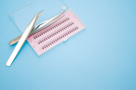 Beauty and fashion concept - tools for Eyelash Extension Procedure. Two tweezers and box with false...
