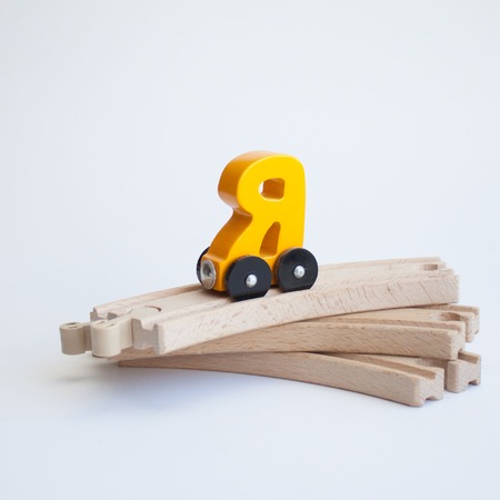 Russian wooden letter train car alphabet. Bright yellow color on wood railway a white background. Early childhood education, learning to read, preschool and kids game conceptの写真素材