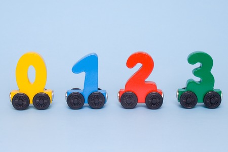 wooden numbers 0,1,2,3 letters train cars alphabet . Bright colors of red yellow green on a white...