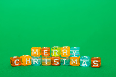words merry christmas made of colorful blocks on green background. Flat lay, top view - holidays,...