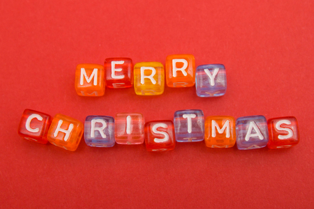 words merry christmas made of colorful blocks on red background. Flat lay, top view - holidays, winter, christmas and new year celebration conceptの写真素材