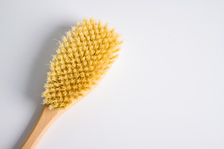 Cosmetology, grooming, spa, beauty and bikini concept. close up wooden soft massage brush for body and legs on white background. space for text.の写真素材