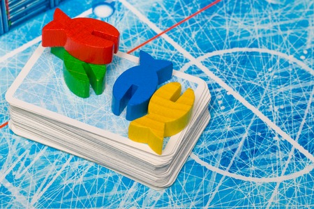 Board game and kids leisure concept - red, yellow, blue, green fish wood chips figure and playing...