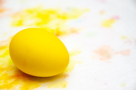 Prepearing for Easter. Painted Yellow color egg on colorful background. copyspace.の写真素材