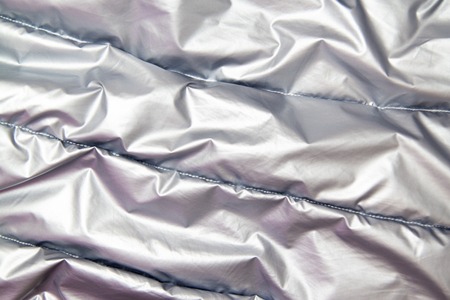 textile and texture concept - close up of crumpled gray silver metallic fabric background