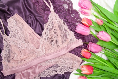 Flat lay, magazines. Top view Woman sexy fashion accessories panties and bra, underwear, purple background. and flowers tulips. Beauty blog conceptの写真素材