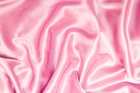 textile and texture concept - close up of crumpled silk pink wavy fabric backgroundの写真素材
