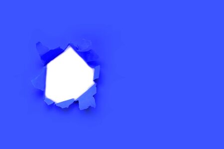 Breakthrough paper hole with white  toned with main trendy Classic Blue color of the year 2020.の写真素材