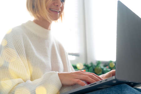 Christmas online shopping, work and education. Woman with notebook computer at home in Santa hat....