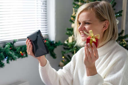 Christmas online congratulations. Smiling woman using mobile tablet for video call friends and...