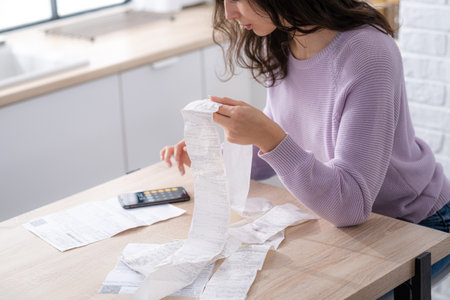 economical woman work on phone calculator at home pay bills taxes on gadget online, provident female calculate finances expenditures, manage plan family household budget on phone.の写真素材