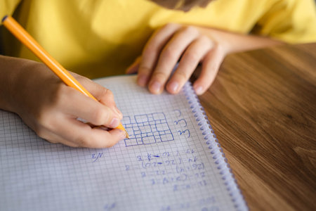 hands pupil close up, school boy going homework at home, writing in notebook