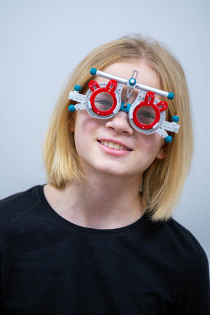 portrait happy little girl patient ophthalmology clinic, vision test in progress cheerful child...