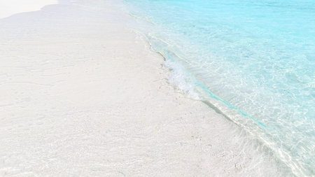 Top view of tropical beach with white sand and clear blue ocean turquoise water in natural sunlight, minimalist peaceful scenery background, relaxation, summer escapeの写真素材