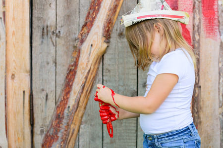 Girl with a brush with red paint, paint the outside barnの写真素材