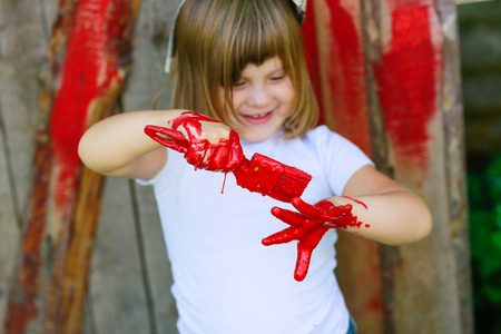 Girl with a brush with red paint, paint the outside barnの写真素材
