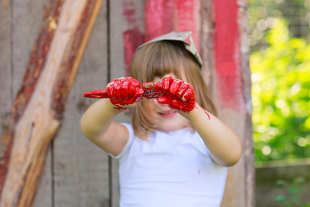 Girl with a brush with red paint, paint the outside barnの写真素材